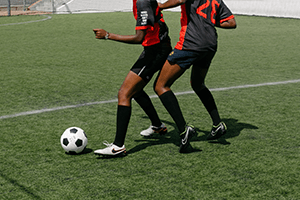 - a photo of the lower halves of two people playing football